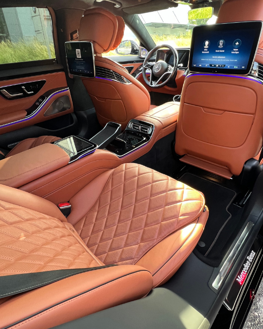 Luxury chauffeur beside a black car ready for a guest