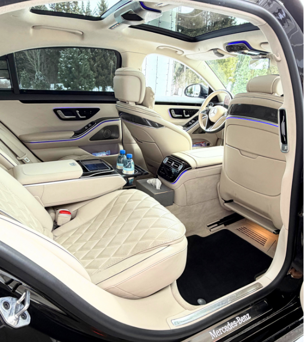 Chauffeur opening the door of a luxury black car